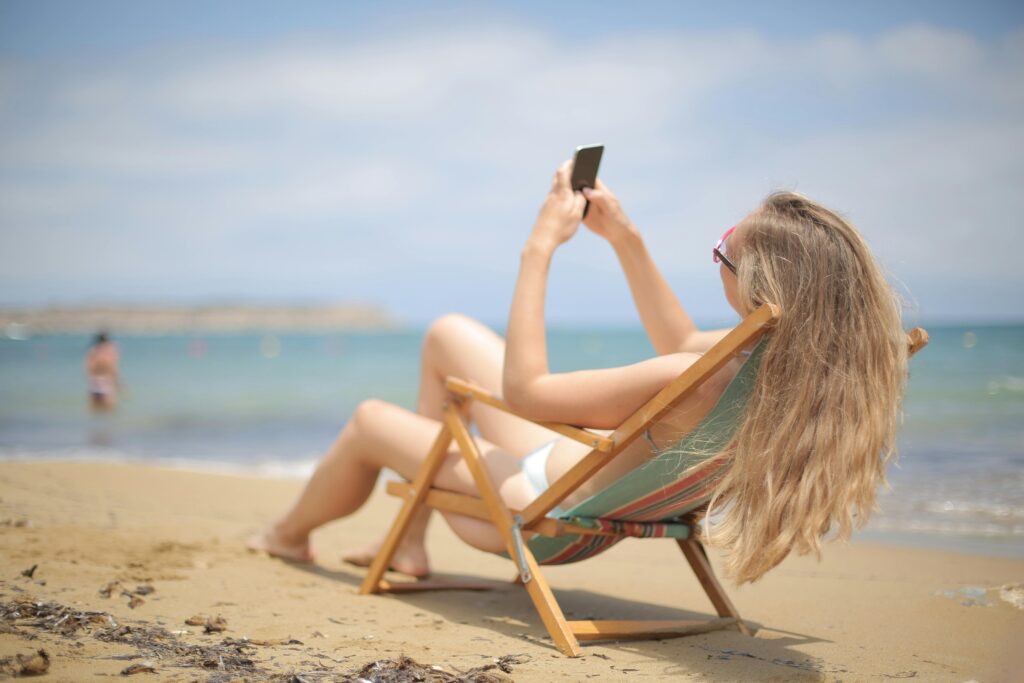 kobieta na plaży ze smartfonem